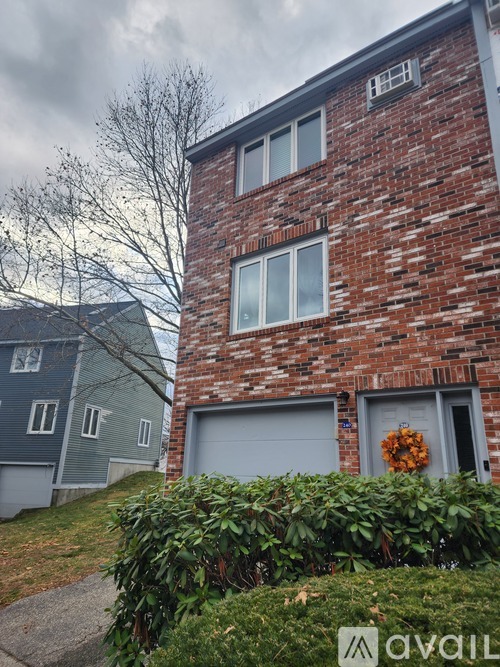 A red brick building with a garage door and a sign that says "available".