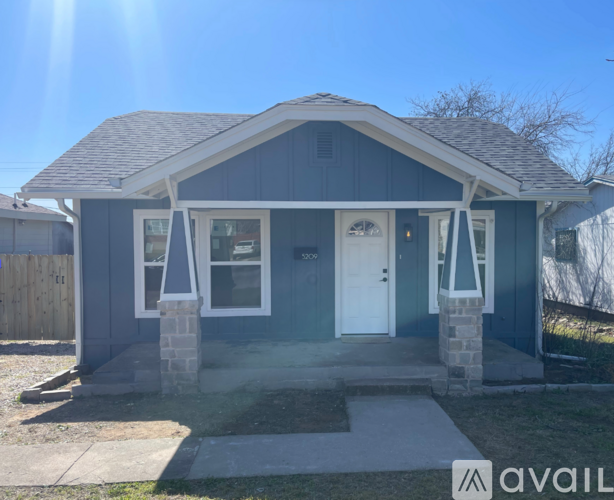 A small house with a white door and windows is available for rent.
