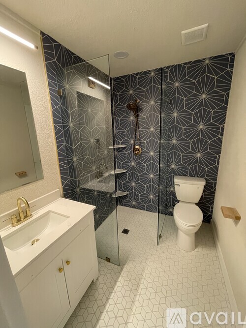 A bathroom with a toilet, sink, and shower.