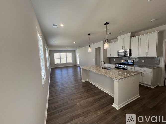 A kitchen with a granite countertop and white cabinets.