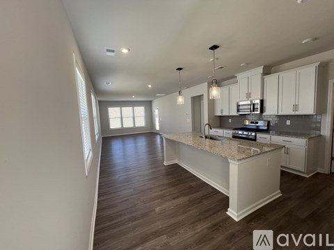 A kitchen with a granite countertop and white cabinets.