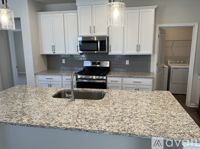 A kitchen with granite countertops and white cabinets.