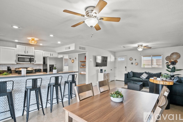 A modern kitchen with a bar area and a dining table.