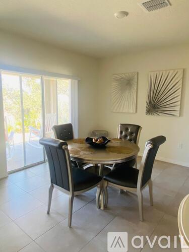 A dining room with a round table and chairs.