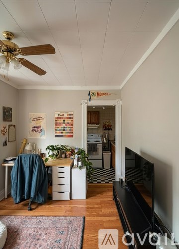 A living room with a television and a rug on the floor.