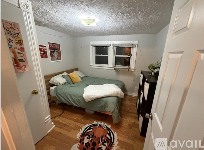 A bedroom with a bed, a window, and a rug.