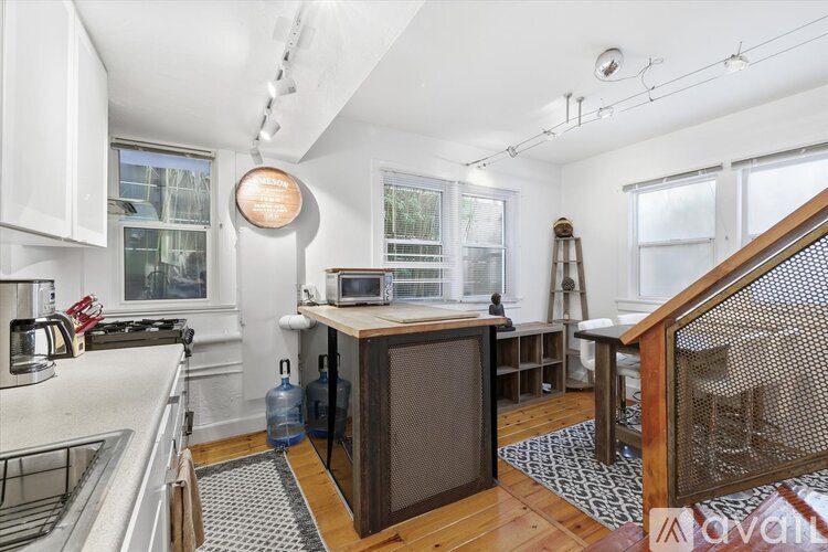 A kitchen with white cabinets and a wooden island.