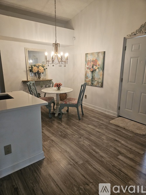 A dining room with a white table and chairs.