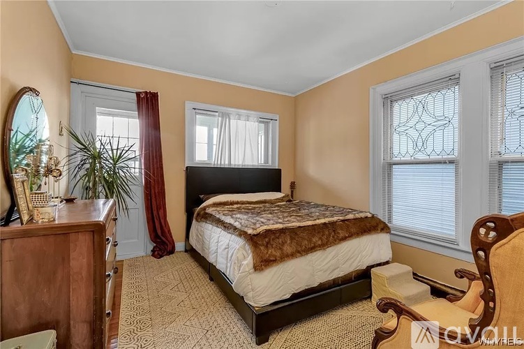 A bedroom with a bed, dresser, and mirror.