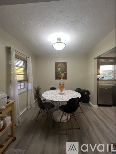 A dining room with a round table and chairs.