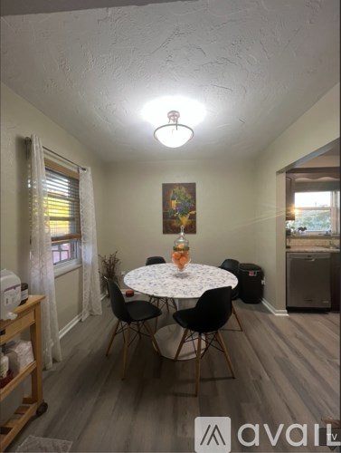 A dining room with a round table and chairs.