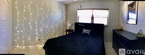 A bedroom with a bed, dresser, and wall decoration.