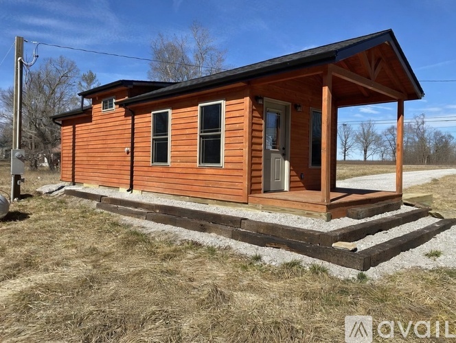 A small wooden cabin with a porch and a door.
