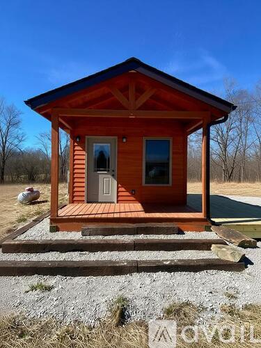A small wooden cabin with a porch and a door.