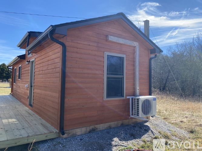 A small wooden cabin with a window and a door is shown.