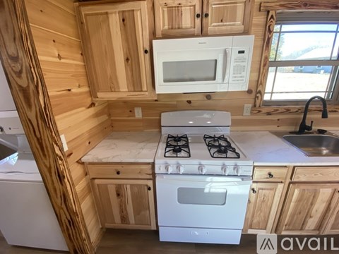 A small kitchen with a stove top oven and a microwave.