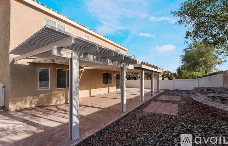 A modern house with a covered walkway and a gravel area in front.