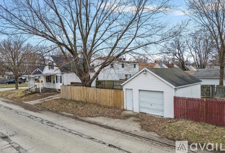 A residential street with houses and bare trees.