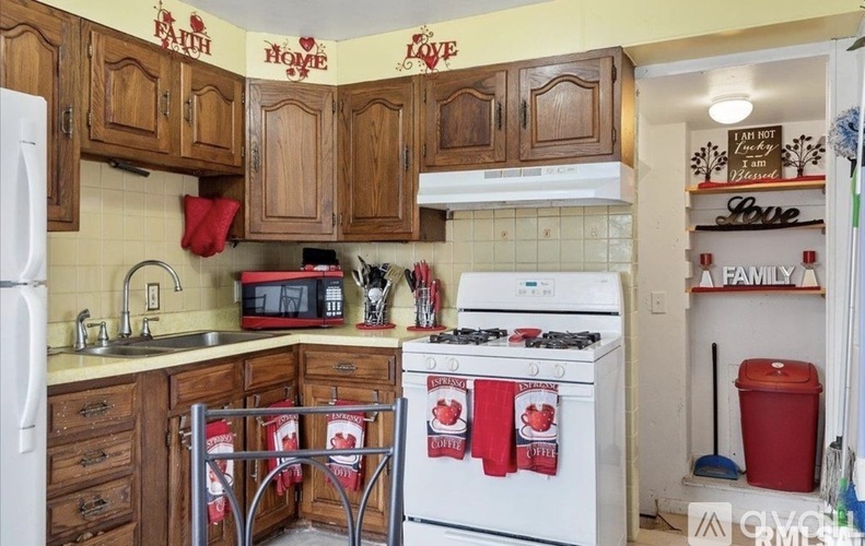 A kitchen with wooden cabinets and a white stove top oven.