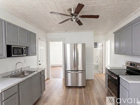 A kitchen with a refrigerator, sink, and stove.