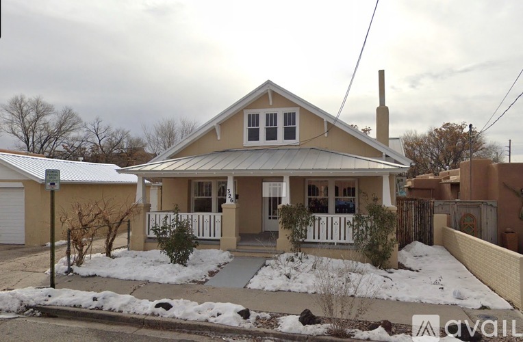 A house with a white fence and a snow-covered ground.