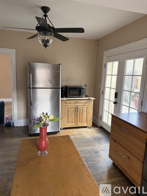 A kitchen with a wooden table and a vase with flowers on it.