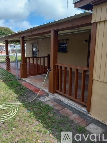 A wooden porch with a hose on the ground.