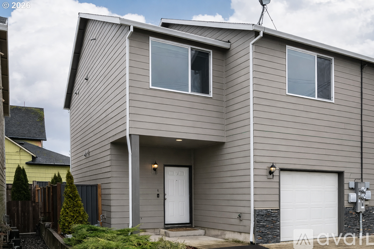 A house with a grey siding and a white door is shown.