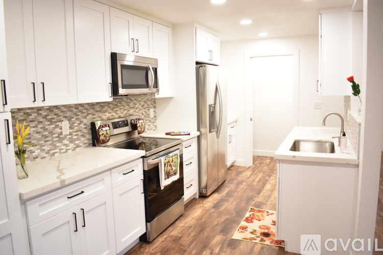 A kitchen with white cabinets and a tile backsplash.