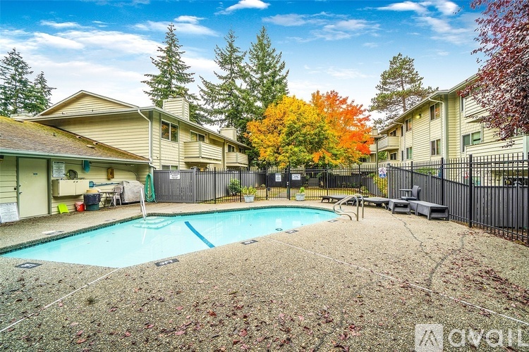 A swimming pool surrounded by a black fence in a backyard.