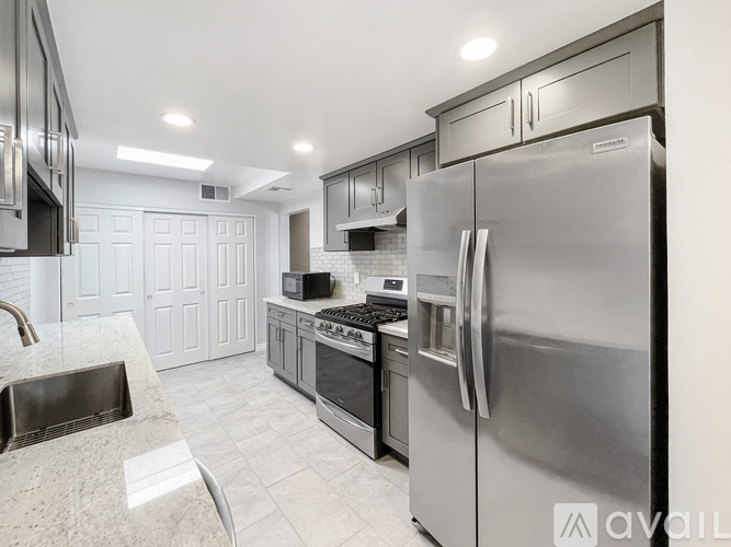 A modern kitchen with stainless steel appliances and white cabinetry.