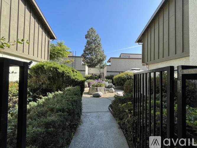 A garden pathway leads to a building with a sign that reads "AVAILABLE".