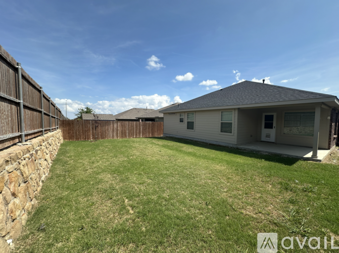 A house with a stone wall and a fence is available for rent.