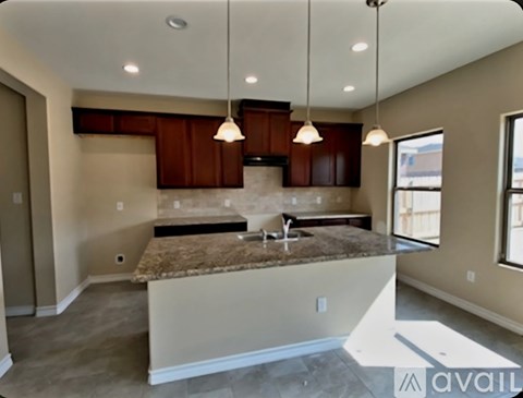 A kitchen with brown cabinets and a granite countertop is available.