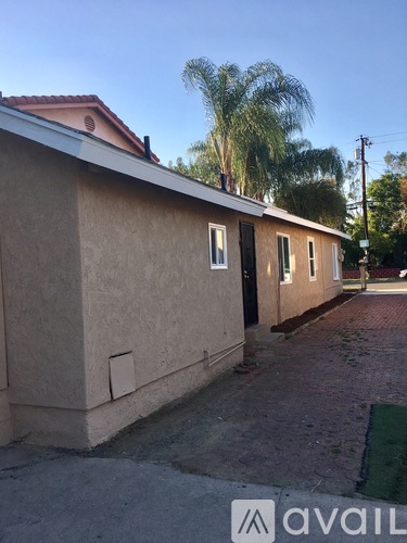 A small building with a red roof and a sign that says "avail" in front of it.