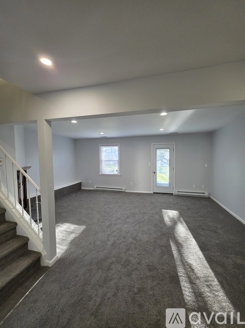 A spacious room with a staircase leading to the upper floor.