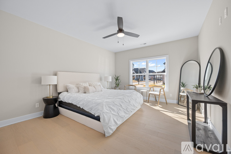 A bedroom with a large bed and a ceiling fan.