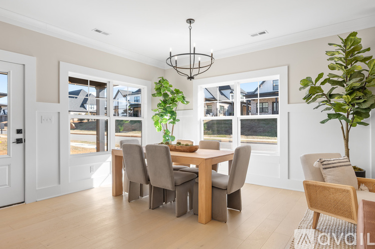 A dining room with a table set for six with a view of the backyard.