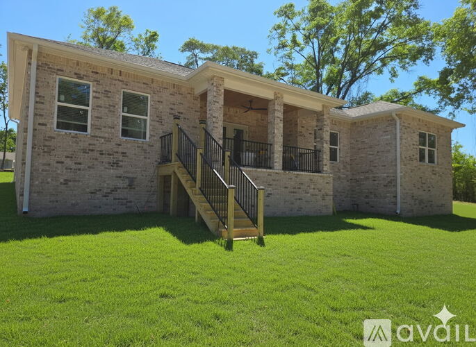 A house with a front yard and a deck.