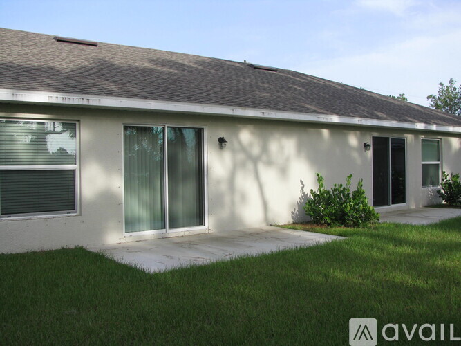 A house with a brown roof and a white wall with a window and a door.
