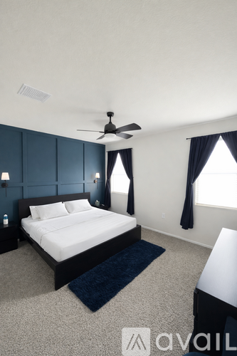 A bedroom with a bed, nightstand, and window with curtains.