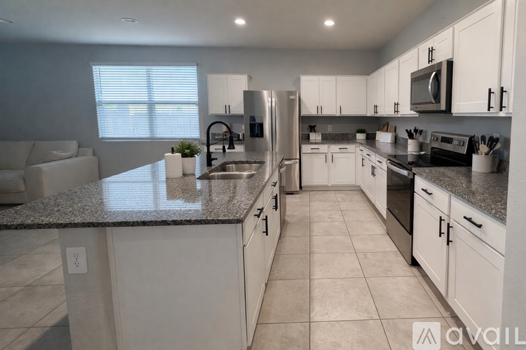A kitchen with white cabinets and appliances.