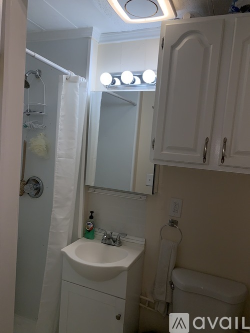A bathroom with a sink, mirror, and toilet.