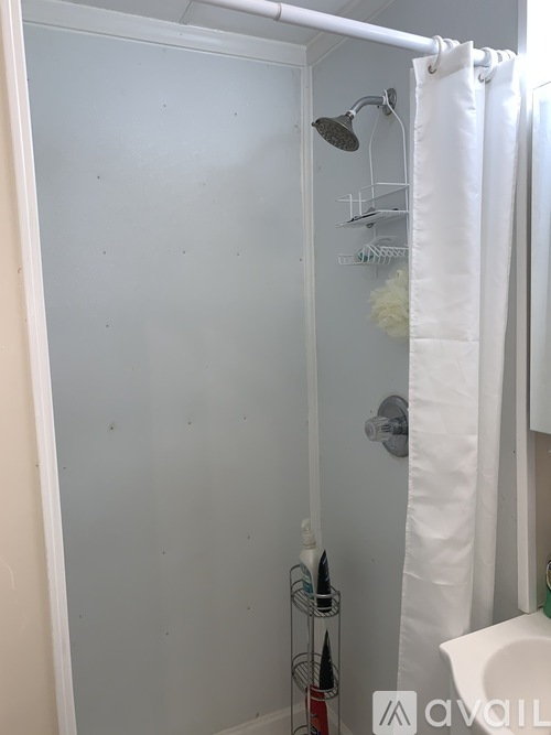 A white shower curtain is hanging in a bathroom.
