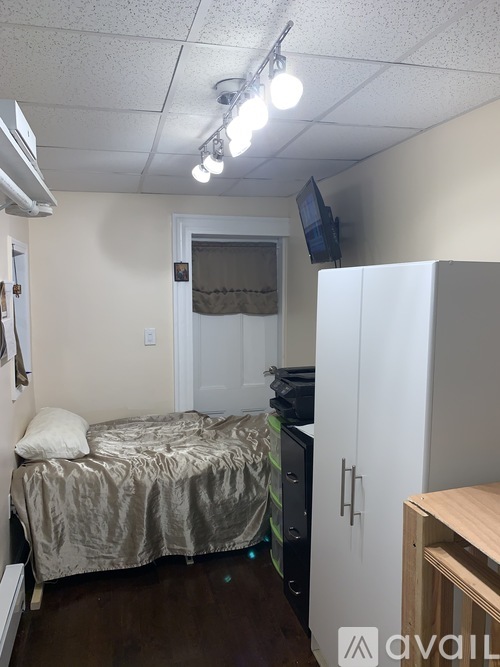 A bedroom with a bed, a TV, and a cabinet.