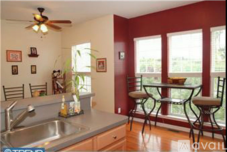 A kitchen with red walls and a table with chairs.
