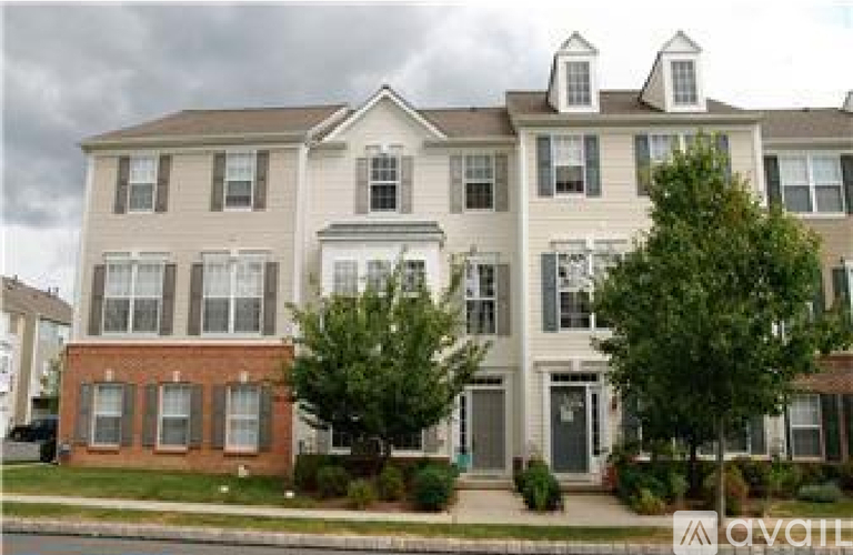 A two-story house with a brick foundation and a grey roof.