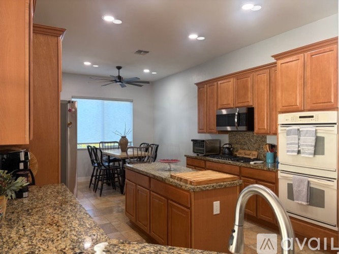 A kitchen with wooden cabinets and granite countertops.