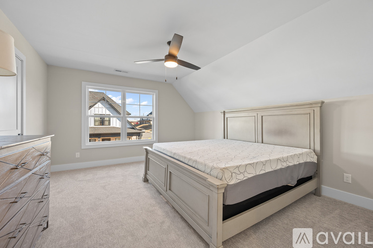 A bedroom with a large bed and a ceiling fan.