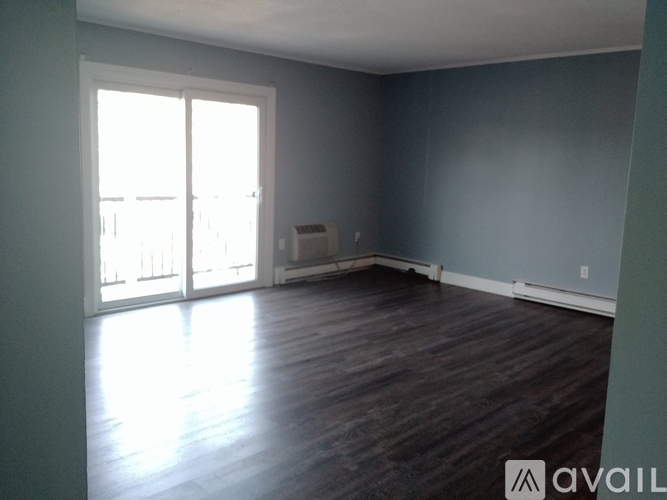 A room with wooden flooring and a large window.